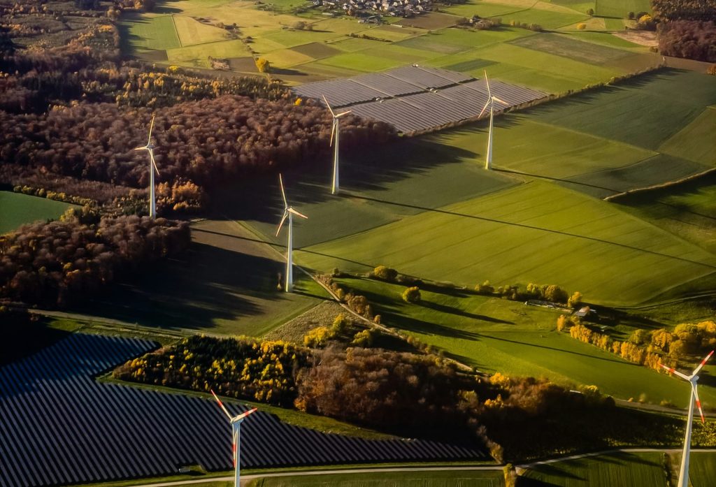 Aerogeneradores y paneles solares en un paisaje rural.
