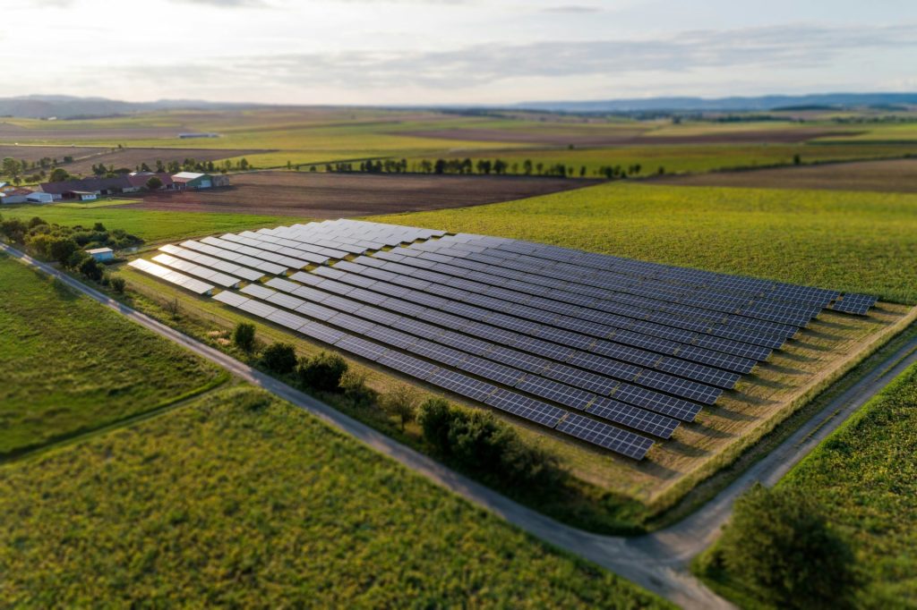Paneles solares negros sobre un campo de hierba verde durante el día