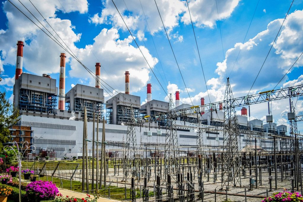 Una central eléctrica con muchas líneas de alta tensión delante.